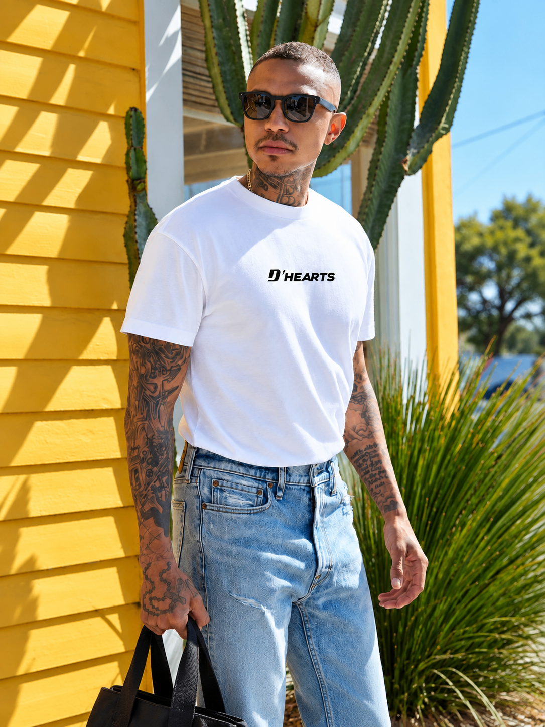 Man wearing a white D'HEARTS unisex tee with light denim